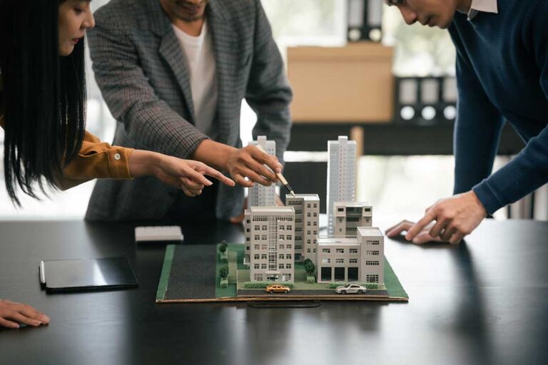 A real estate agent meets with a family at a kitchen table, reviewing documents and discussing a home purchase.